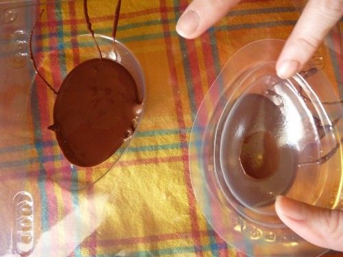 Colocando o chocolate derretido na forma de ovo de páscoa